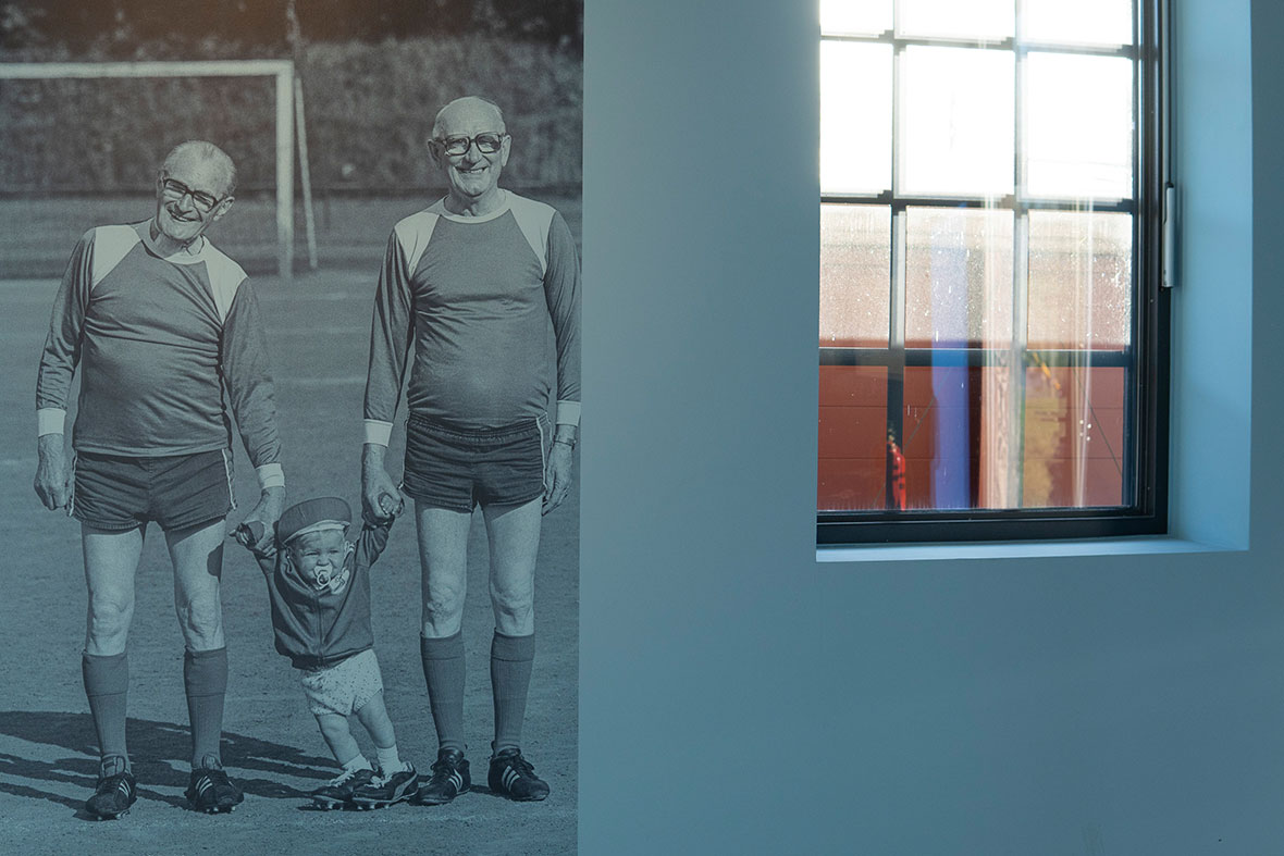 Zwei Altherrenfußballer mit Kleinkind, Großfoto